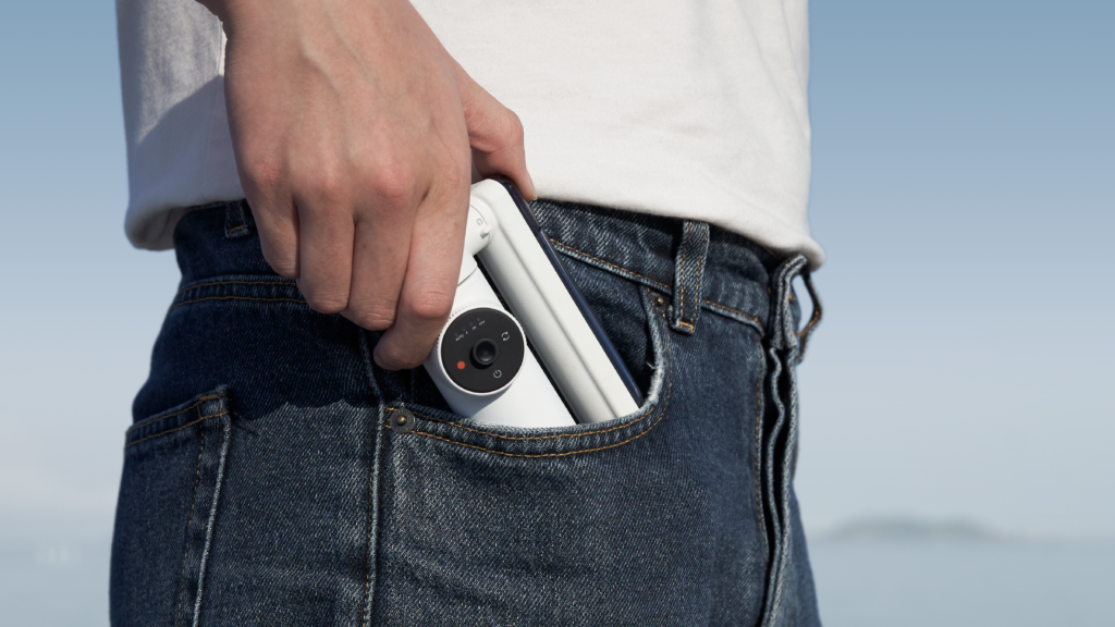 a person holding a video camera in their pocket