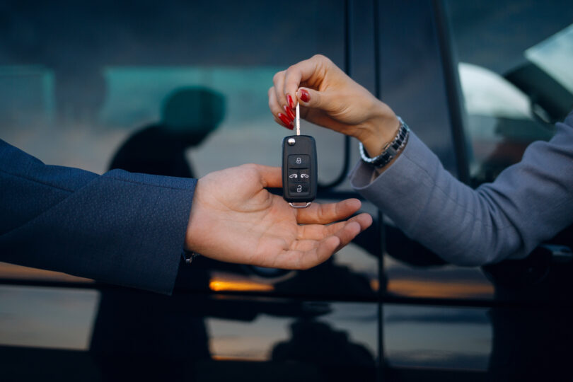 a person handing over a car key