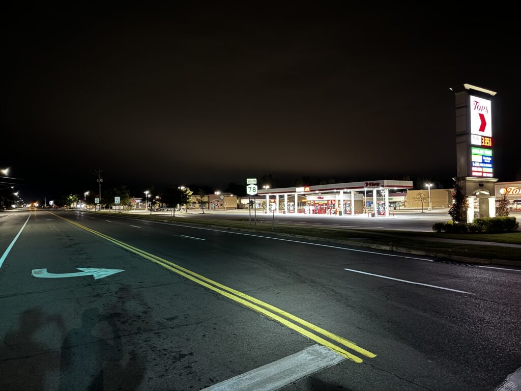 a road with a gas station at night