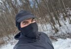 a man wearing a mask and hat in the snow