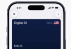 The image shows a smartphone screen displaying a digital ID card. The card is dark blue with the text "Digital ID" and "Kelly G." on it. There is a small American flag icon with the words "Passport Verified" next to it. The phone's status bar shows the time as 9:41, with icons for signal strength, Wi-Fi, and battery. There are also circular icons for closing and information at the top corners of the screen.
