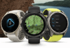 The image shows three Garmin smartwatches with different displays. The left watch has a charging icon on its screen, the middle watch displays a topographic map, and the right watch shows a menu with options like "Kayak," "Apnea," "Dive," "Snorkel," and "Surf." The watches have different band colors: white, black, and yellow. The background features a rocky surface and a scenic view of a lake with hills.
