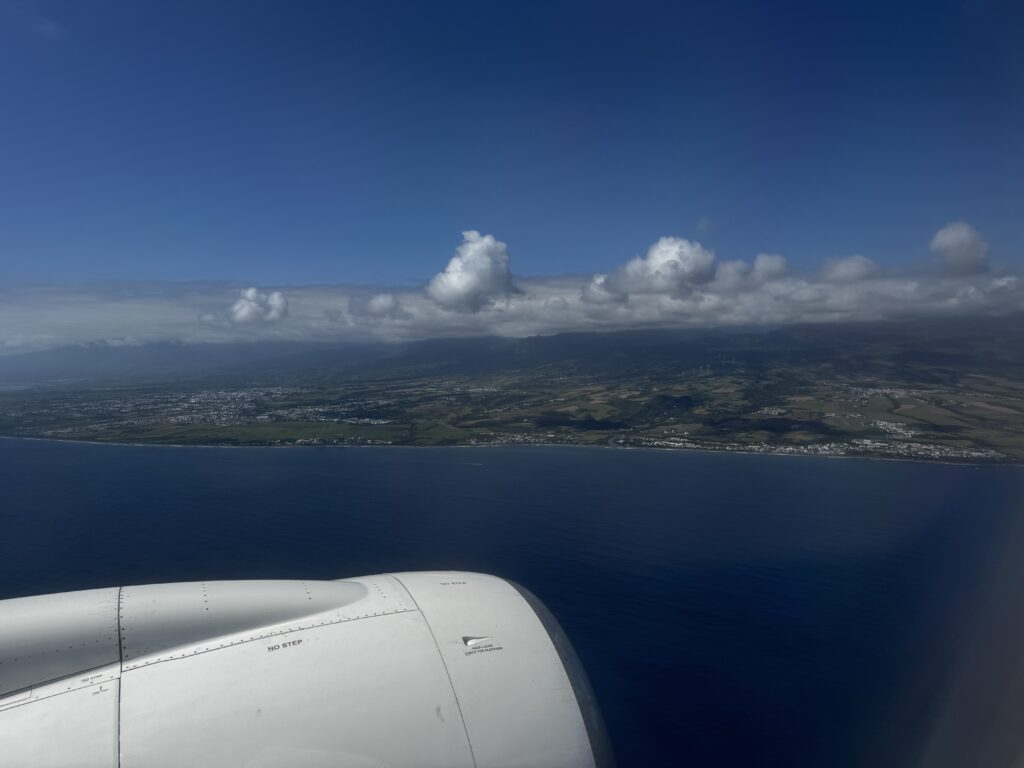 a view of a land and the ocean from an airplane