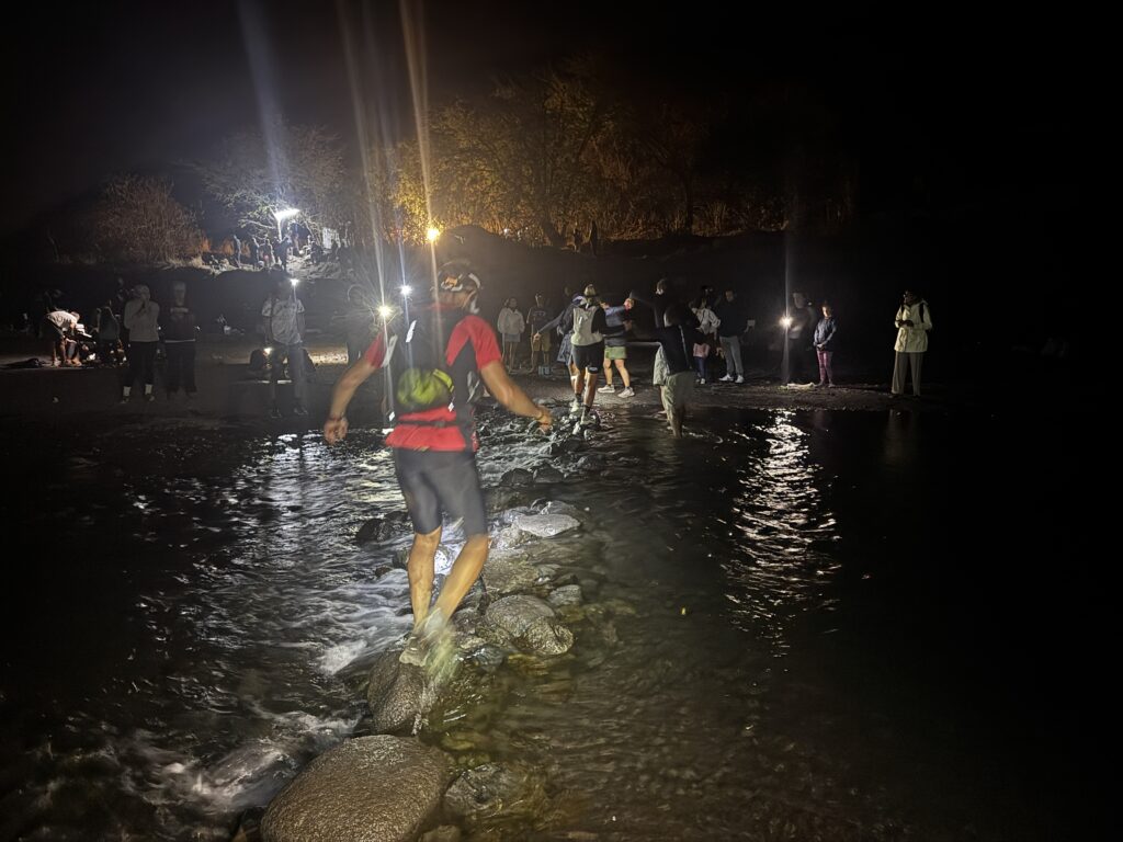 a man walking on rocks in water at night