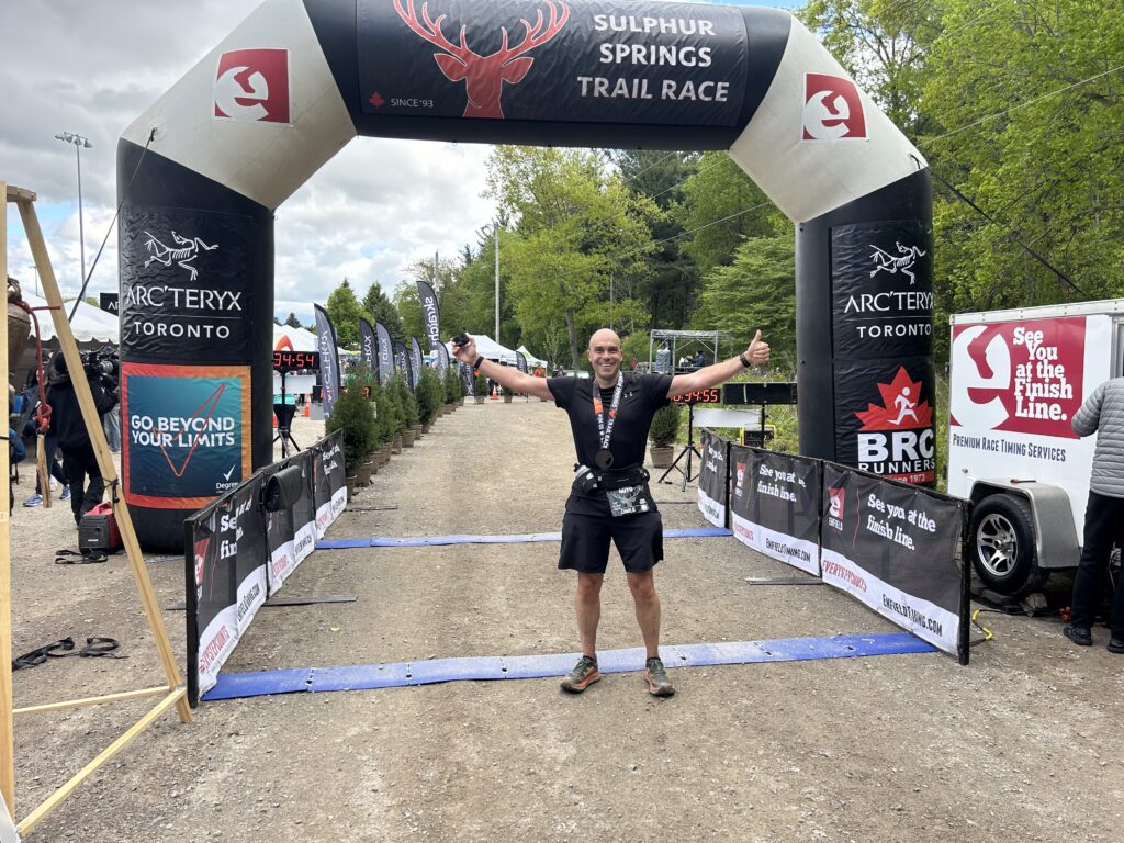 a man standing in front of a black and white arch